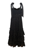 Black dress with gold polka dots on a white background