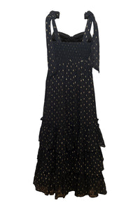 Black dress with gold polka dots on a white background