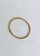 elegant open gold bangle displayed on white surface for a modern look