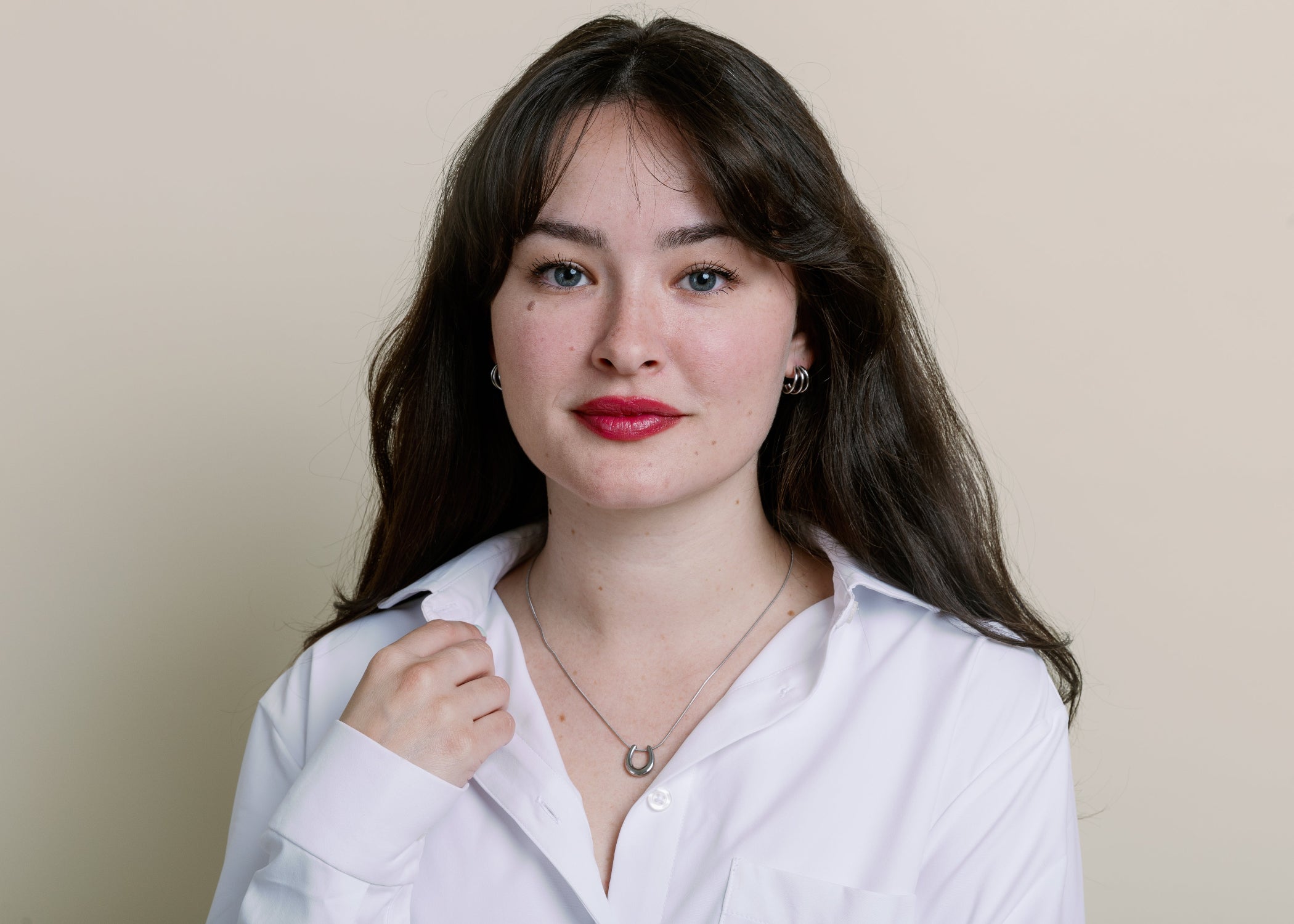Model wearing silver hold your horses necklace standing against neutral background