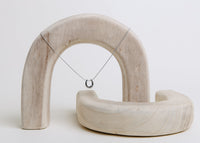 minimalist silver horseshoe charm necklace styled on neutral display background.